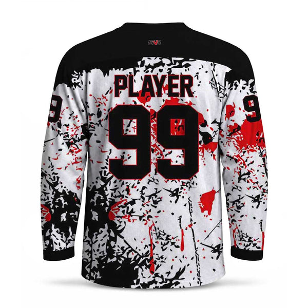 Back view of a long-sleeve hockey jersey with personalized name and number in black, featuring a white base with black splatter graphics and red blood-splatter accents.