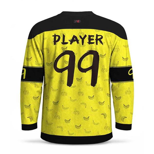 A long-sleeve hockey jersey shown from the back, with a bright yellow body covered in small banana illustrations, black shoulder panels, black horizontal sleeve stripes, and large black personalized name and number on the back.