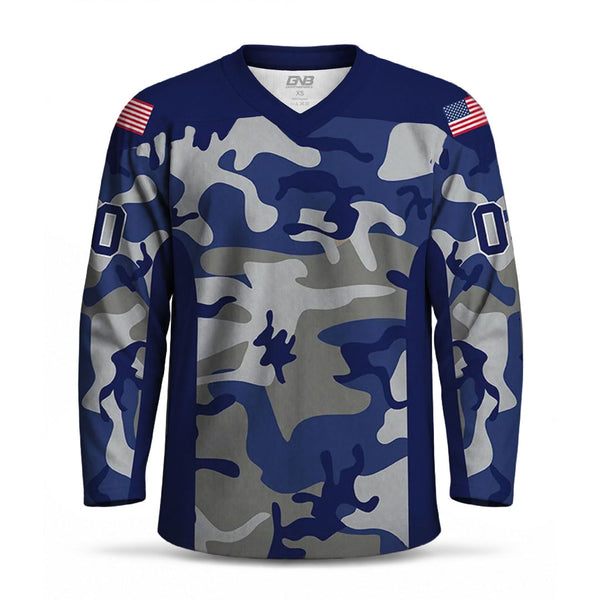 A long-sleeve V-neck hockey jersey with a blue, gray, and navy camouflage pattern, featuring American flag patches on the shoulders and a large white customized number on each sleeve.