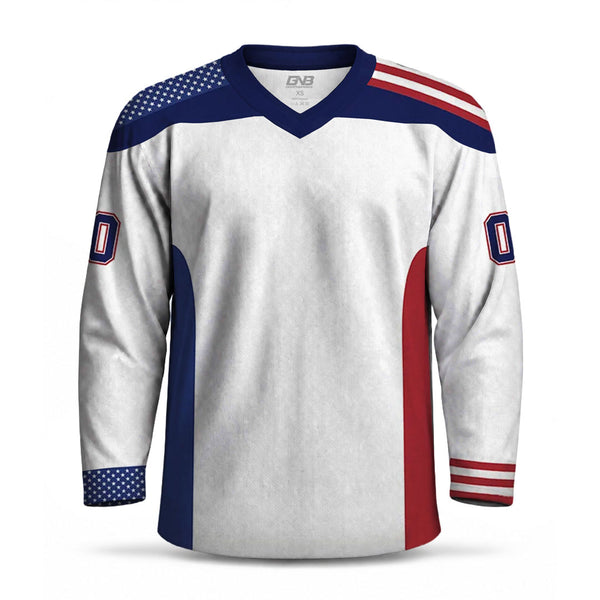 A white long-sleeve hockey-style jersey with navy blue and red accents, featuring an American flag pattern on the shoulders and sleeves, a V-neck collar, and a stylized number on the sleeves.