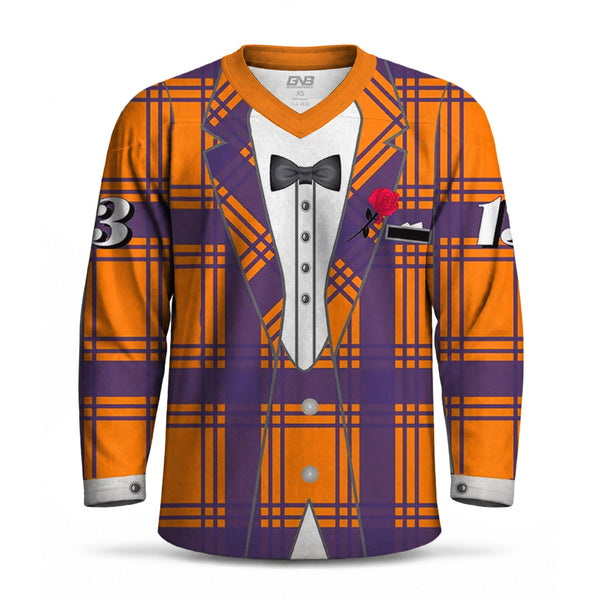 A long-sleeve V-neck hockey jersey with an all-over print of a purple and orange plaid tuxedo jacket over a white tuxedo shirt, featuring a black bow tie, a red rose boutonniere, and number patches on the sleeves.