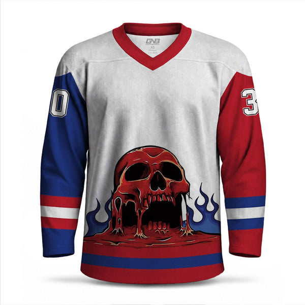 A long-sleeve hockey-style jersey with a white body, red collar and sleeve caps, blue sleeves, and a large red skull graphic with flames across the front.