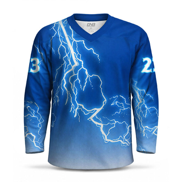 A long-sleeve blue V-neck athletic hockey jersey with a lightning bolt graphic pattern in white and blue, featuring the number on both sleeves.