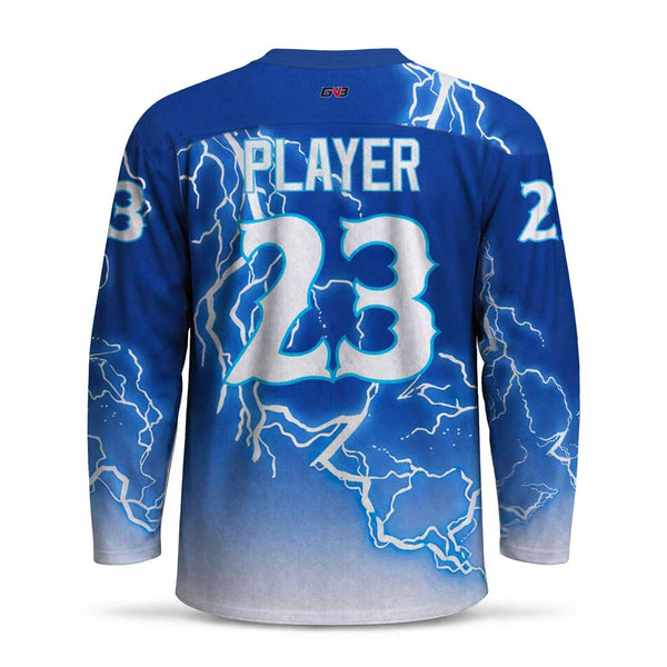 A long-sleeve hockey jersey shown from the back, featuring a blue gradient that fades to white at the hem, decorated with white lightning bolt graphics. The back is personalized with the name and the number in white with a blue outline.