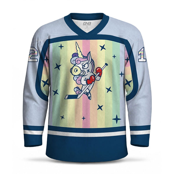 A long-sleeve hockey jersey with a light blue body, navy blue trim, and a pastel rainbow stripe graphic on the front featuring a cartoon unicorn playing hockey. The jersey has the personalized number on the sleeve.