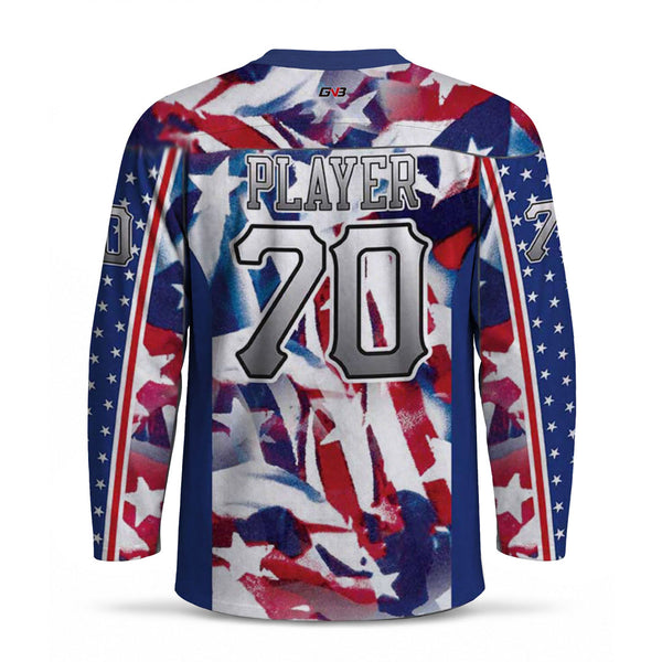 A long-sleeve hockey jersey shown from the back, featuring a patriotic red, white, and blue distressed flag pattern with white stars on the sleeves. The back is printed with personalized name and number in a gray and white outlined font.